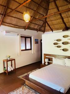 Mangal Beach Lodge في فيلانكولوس: غرفة نوم بسرير وسقف خشبي