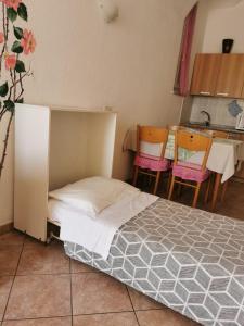 1 dormitorio con 1 cama, mesa y sillas en Residence Celeste, en Mezzegra