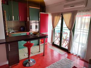 una cocina con armarios rojos y verdes y una mesa en Apartman Cvetić, en Kragujevac