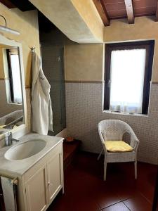 a bathroom with a sink and a mirror and a chair at Charming Townhouse with Garden in Impruneta