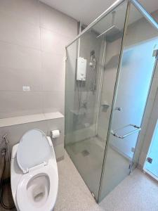 a bathroom with a toilet and a glass shower at Mari Mari Homestay - IMAGO THE LOFT in Kota Kinabalu
