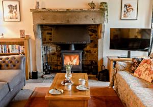 a living room with a couch and a fireplace at High Green Cottage in Low Eskcleth