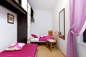 a small room with two beds and a chair at Apartment Della Croce in Sutivan