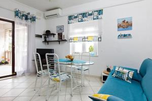 a living room with a blue couch and a table and chairs at Apartment Della Croce in Sutivan