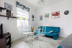 a living room with a blue couch and a table and chairs at Apartment Della Croce in Sutivan