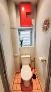 ein Badezimmer mit einer Toilette und einem roten Schild darüber in der Unterkunft Le Cyrano - Versailles in Versailles