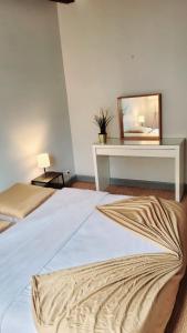 Schlafzimmer mit einem Bett mit einem Spiegel und einem Tisch in der Unterkunft Le Cyrano - Versailles in Versailles + 6 Fotos