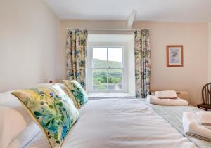 een groot bed in een kamer met een raam bij Heather View in Gunnerside