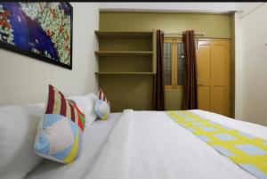 a bedroom with a white bed with two pillows at Bv Stayz in Chennai