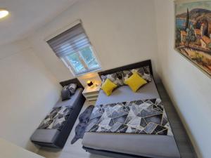 two beds in a room with a window at Modern Dream Apartment in Neum
