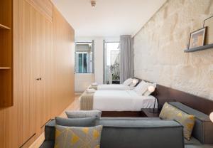 a bedroom with a bed and two chairs at NOLIA Boutique Hotel in Porto