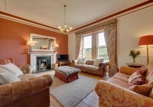a living room with two couches and a fireplace at Hazel Brow House in Feetham