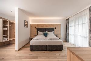 a bedroom with a large bed and a large window at Familienresort Reslwirt in Flachau
