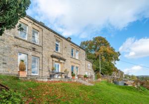 a brick house with a grassy yard in front of it at Hazel Brow House in Feetham