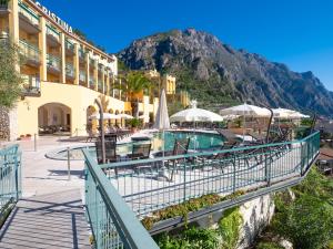 ośrodek z basenem, stołami i parasolami w obiekcie Hotel Cristina w mieście Limone sul Garda