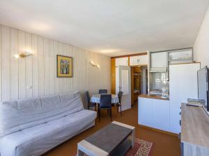 ein Wohnzimmer mit einem weißen Sofa und einer Küche in der Unterkunft Studio Gourette, 1 pièce, 4 personnes - FR-1-400-46 in Gourette