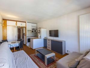 a living room with a couch and a tv at Studio 4 pers, pied des pistes, balcon, kitchenette équipée, Gourette - FR-1-400-46 in Gourette