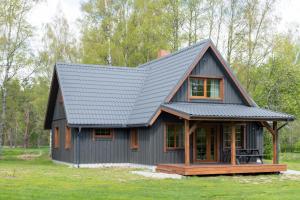 a black house with a gambrel roof at Brīvdienu māja Vējiņi in Straupe