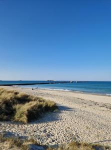 une plage de sable avec l'océan en arrière-plan dans l'établissement Villa Fresquet, à Cherbourg en Cotentin