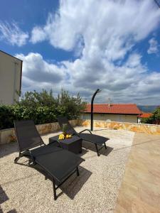 two chairs and a table on a patio at Apartment Tina, Modern, Private SeaView Outdoor Terrace, BBQ, close to beach, 2 bedrooms in Trogir