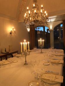 ein Esszimmer mit einem langen weißen Tisch mit Kerzen in der Unterkunft QUISIGUSTA Luxury B&B in Curio