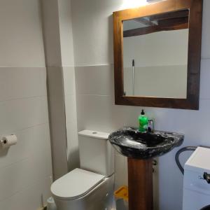 a bathroom with a sink and a toilet and a mirror at Invernal de Tobaño in Cahecho