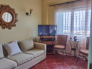 a living room with a couch and a flat screen tv at Evaggelia's Seaside Boutique Apartment in Iraion