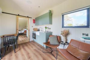 a kitchen and living room with a table and chairs at Luna's Lookout in Cilcain