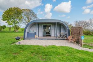 een klein koepelhuis met een tafel en stoelen in een veld bij Luna's Lookout in Cilcain