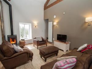 a living room with a couch and a fireplace at Sunny Brow Hayloft in Ambleside