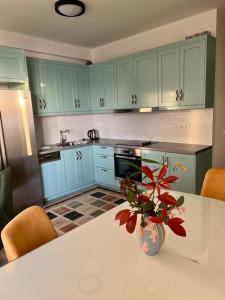 een keuken met een tafel met een vaas met bloemen erop bij White SideSea View Apartment in Sarandë