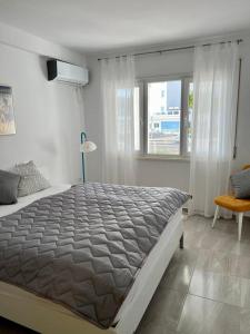 een slaapkamer met een groot bed en een raam bij White SideSea View Apartment in Sarandë