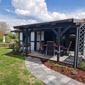 een pergola met een tafel en stoelen op een patio bij Ferienhaus Elbdiek in Bachenbrock