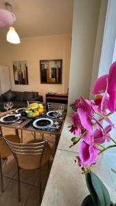 een woonkamer met een tafel met paarse bloemen bij Patras Port apartment in Patra