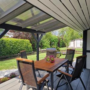 Une table et des chaises en bois sont disponibles sur la terrasse. dans l'établissement Ferienhaus Elbdiek, à Bachenbrock