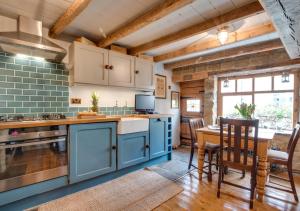 a kitchen with blue cabinets and a table and chairs at Green Cottage in Robin Hood's Bay