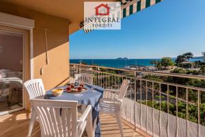 a balcony with a table and chairs and the ocean at Torre Marina Apartments in Calonge