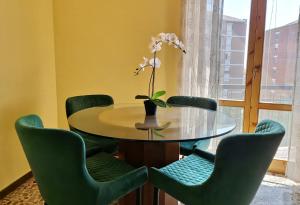 a dining room with a table and green chairs at Giardino sul Naviglio in Milan