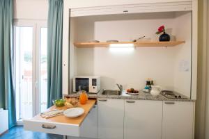 cocina con armarios blancos y encimera en Cav Approdo, en Castiglione della Pescaia
