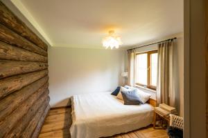 Un dormitorio con una cama y una pared de madera. en Brīvdienu māja Vējiņi, en Straupe