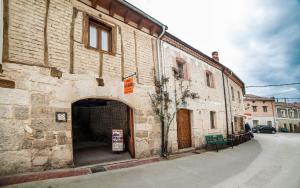 an old stone building with an archway on a street at Santa Brigida - Real 19 in Hontanas