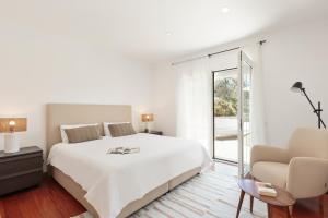 biała sypialnia z dużym łóżkiem i kanapą w obiekcie Luxury Seaview Villa by Olala Homes w mieście Teià