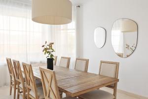 comedor con mesa de madera y sillas en Luxury Seaview Villa by Olala Homes en Teià