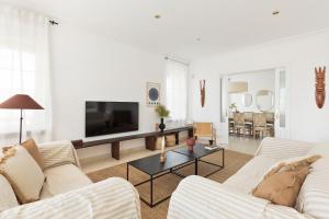 salon z białymi meblami i telewizorem z płaskim ekranem w obiekcie Luxury Seaview Villa by Olala Homes w mieście Teià