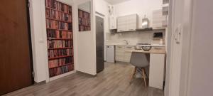 a kitchen with a table and a book shelf filled with books at Casa Roma in Piacenza