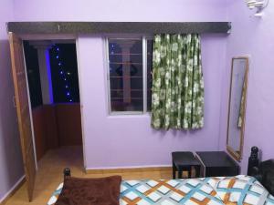 a bedroom with a bed and a window with a curtain at Shahi Residency in Panhāla