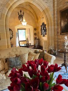 una sala de estar con sofá y un ramo de flores rojas en Château de Clérans en Saint-Léon-sur-Vézère