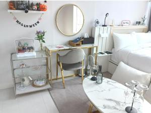 Schlafzimmer mit einem Schreibtisch und einem Bett mit einem Spiegel in der Unterkunft Angel House in Daegu
