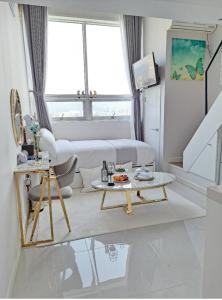ein weißes Wohnzimmer mit einem Tisch und einem Sofa in der Unterkunft Angel House in Daegu