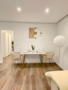 a dining room with a white table and chairs at REGENCY Apartments - Stylische zentrale 50m2 Wohnung mit Balkon, Wasserblick und Netflix in Hannover